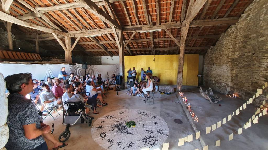 The image depicts a gathering of individuals in a rustic indoor setting, surrounded by a sense of community and connection...